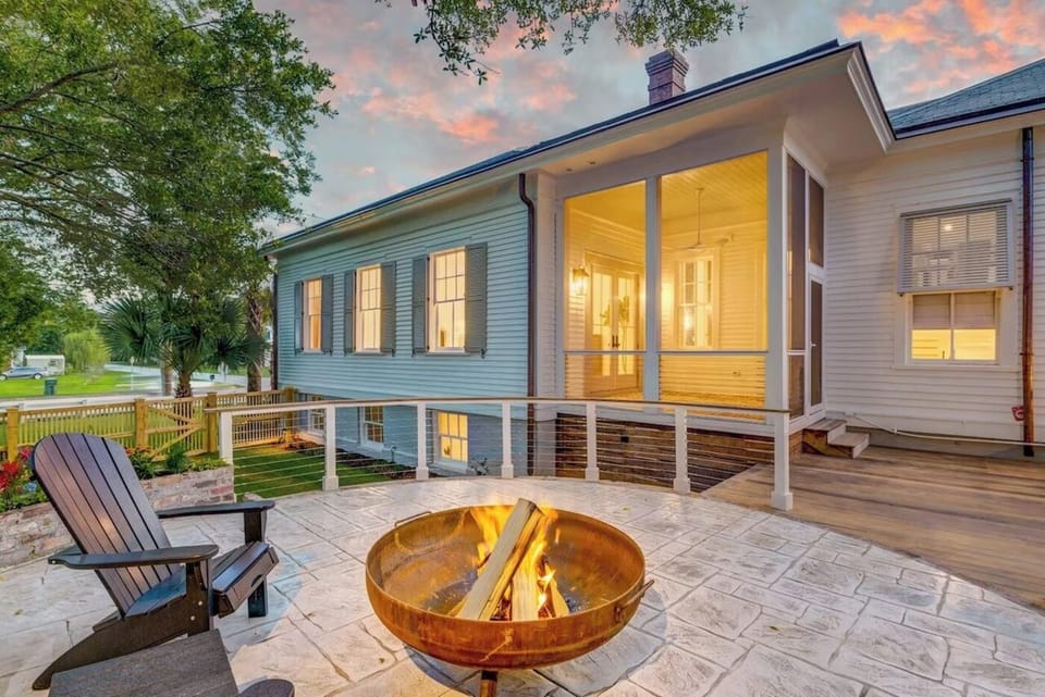 Fire pit and an Adirondack chair on the side patio at dusk